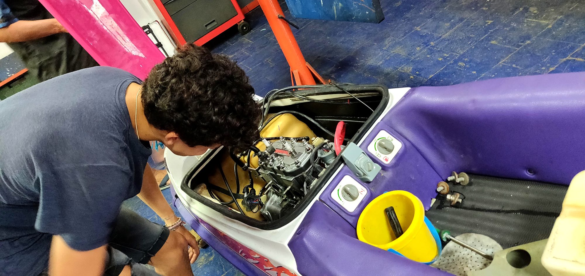 Person working in the open engine bay of the 750 SXi