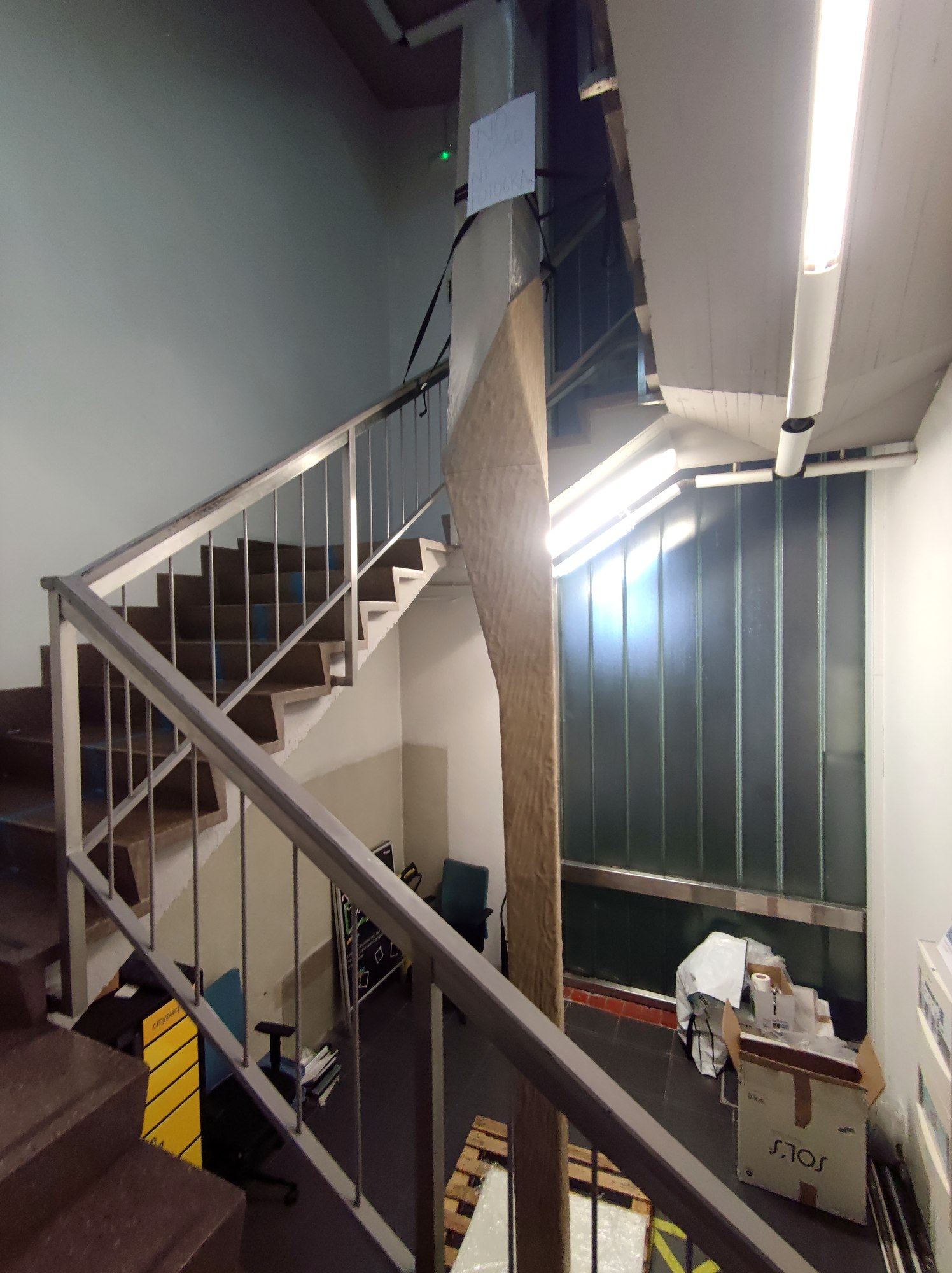 Tall faceted textured pillar standing in a stairwell