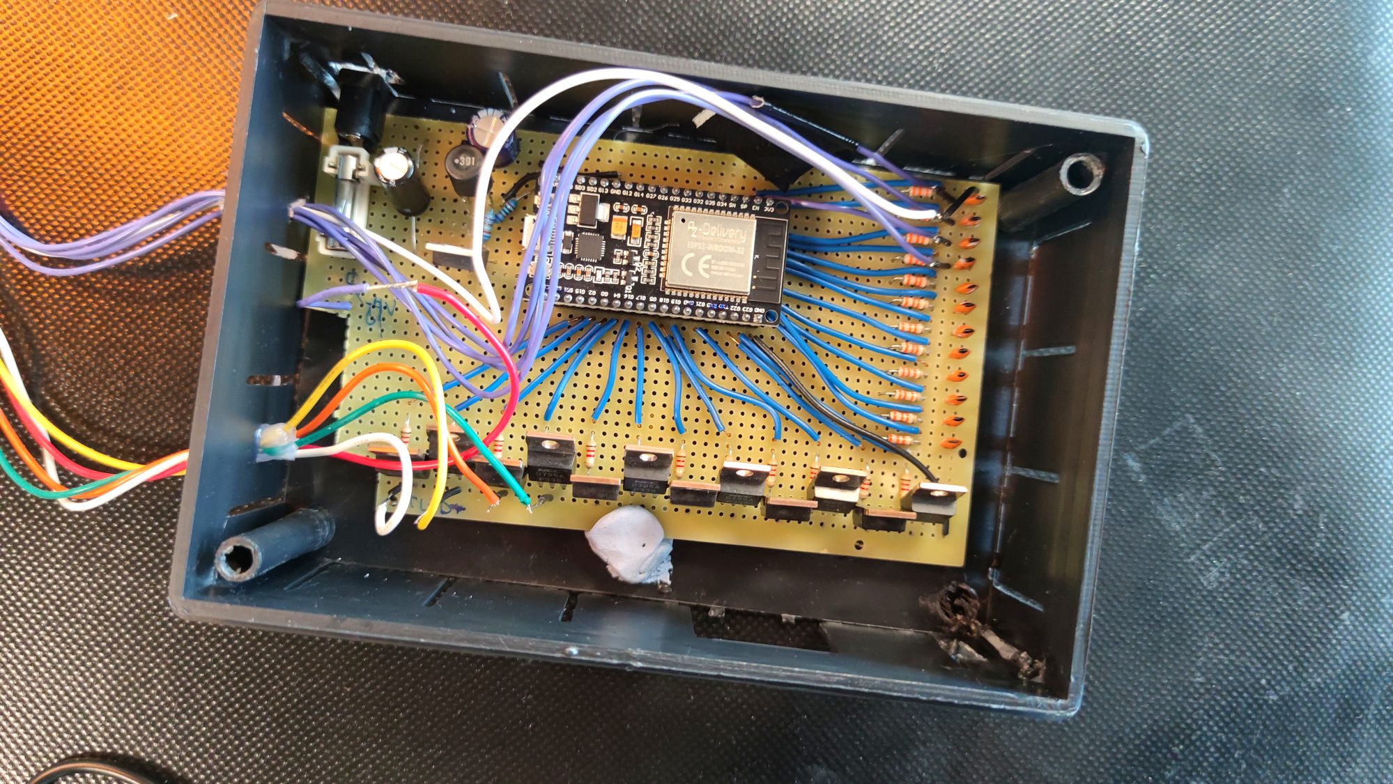 Open black enclosure containing a wired ESP32 perfboard prototype